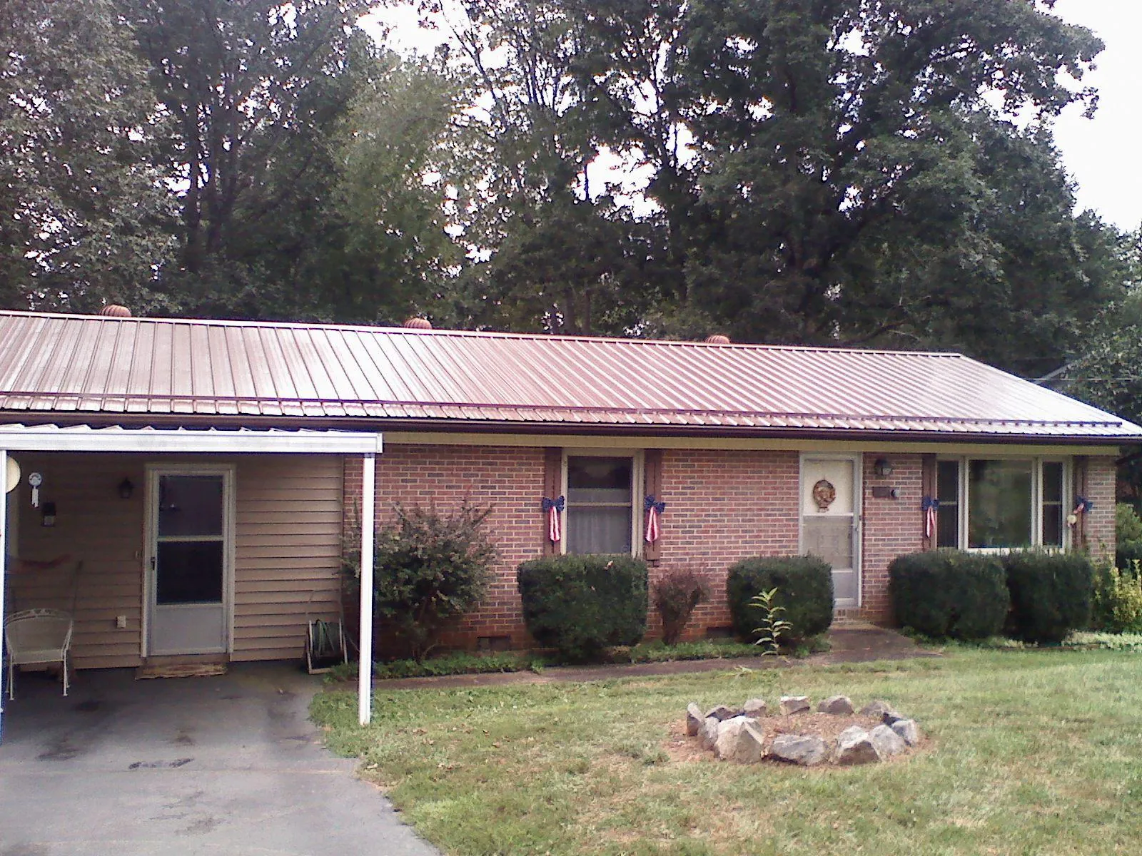 Bronze metal roof and carport on a brick ranch home — Roof Repair work by our crew in Maceo